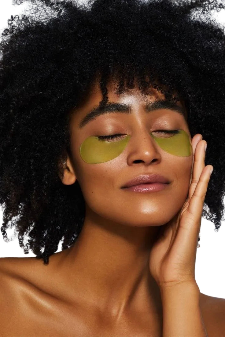 Femme portant des patchs hydrogel dorés sous les yeux pour un traitement anti-cernes et anti-poches, moment de détente spa beauté

